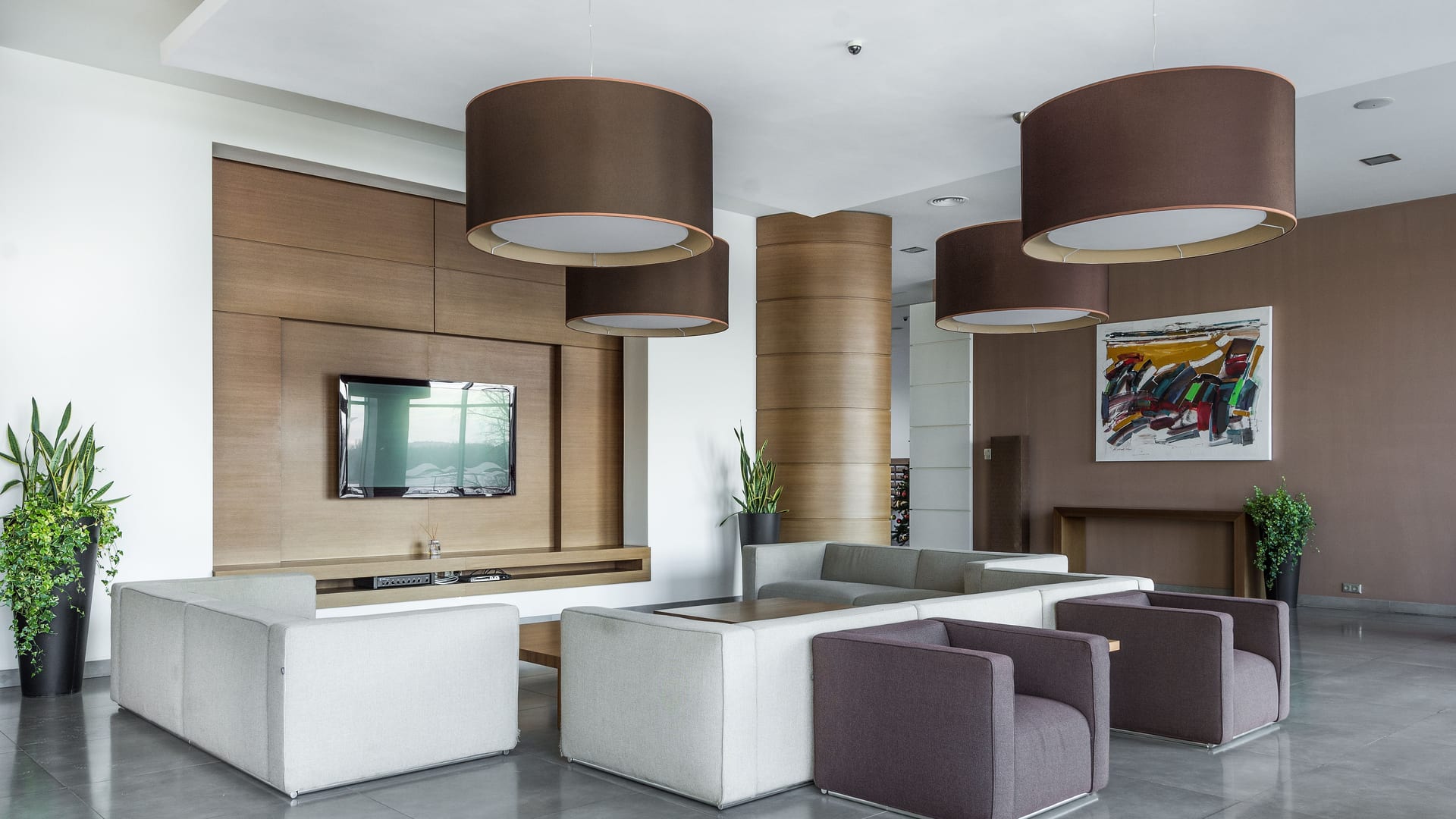Spacious contemporary living room with sofas, a wood wall, and pendant lights