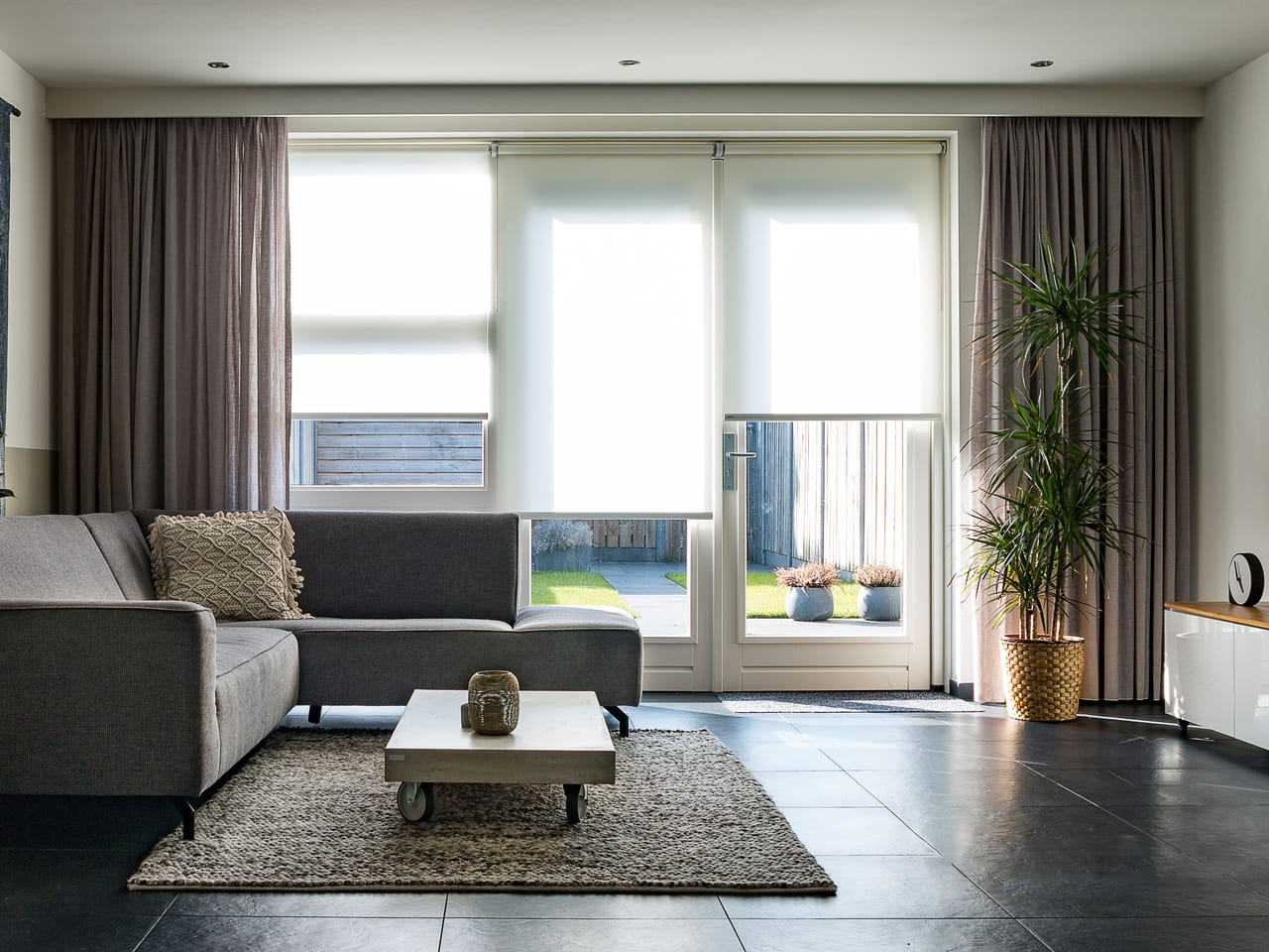 Bright living room with a grey sofa and doors to a garden